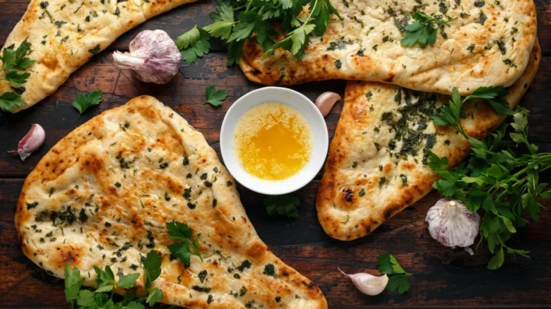 Svěží placky chleba naan s česnekem, bylinkami a máslem.