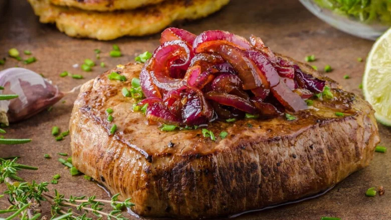 Steak s karamelizovanou cibulkou na talíři.