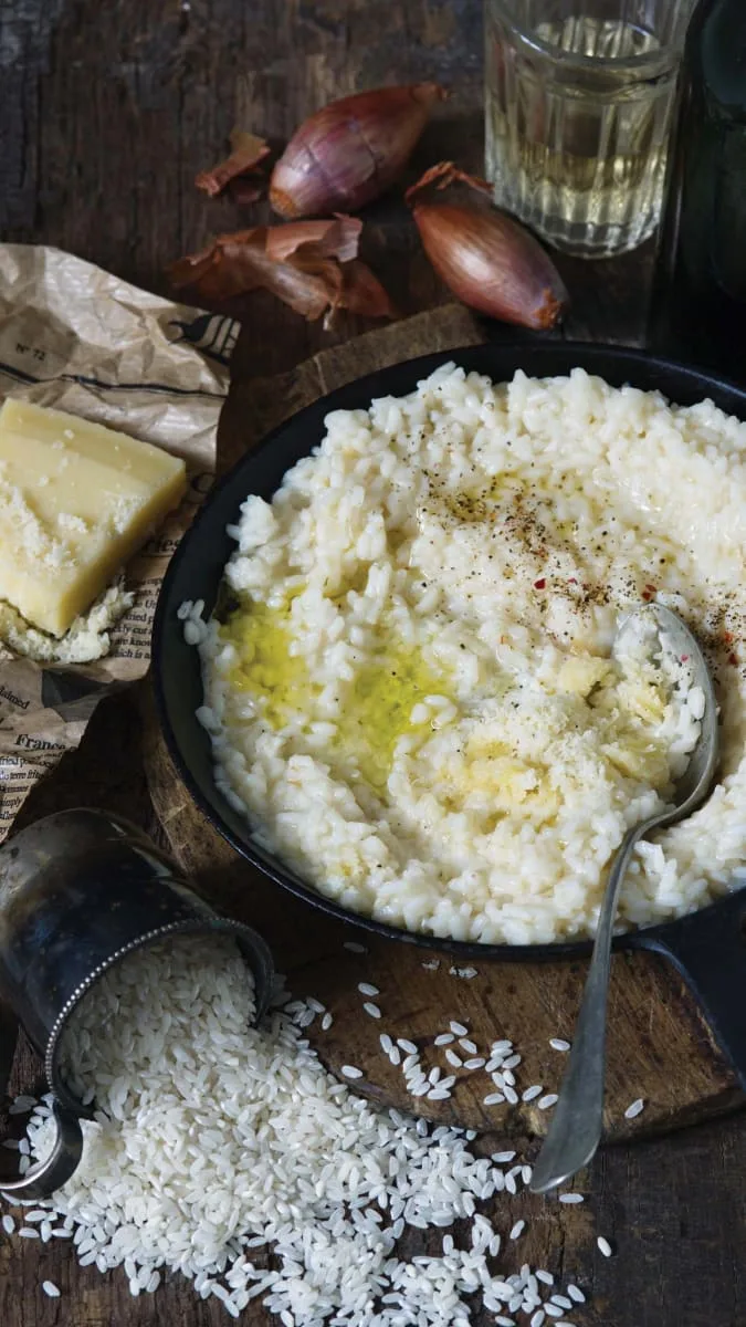 Křemíkový rýže s olejem, česnekem a parmezánem na dřevěném podkladu.