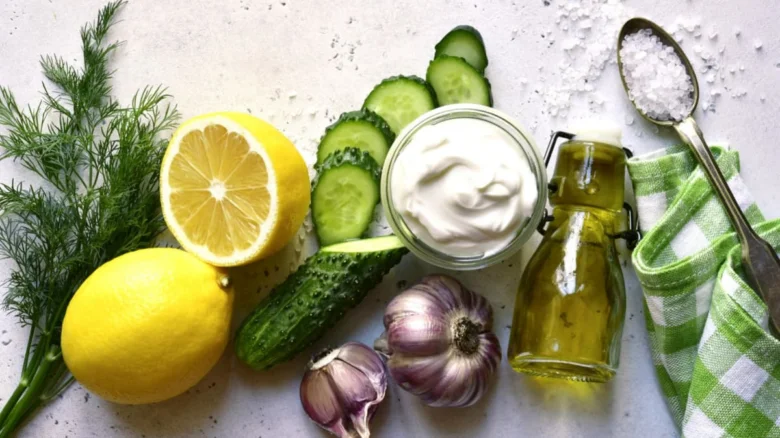 Suroviny na domácí tzatziki: citrony, okurky, česnek, koprováček.
