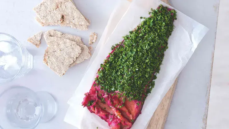 Gravlax losos s bylinkami a řepou na pečicím papíru.