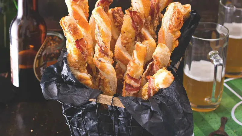 Tyčinky z listového těsta se slaninou a sýrem v košíku.