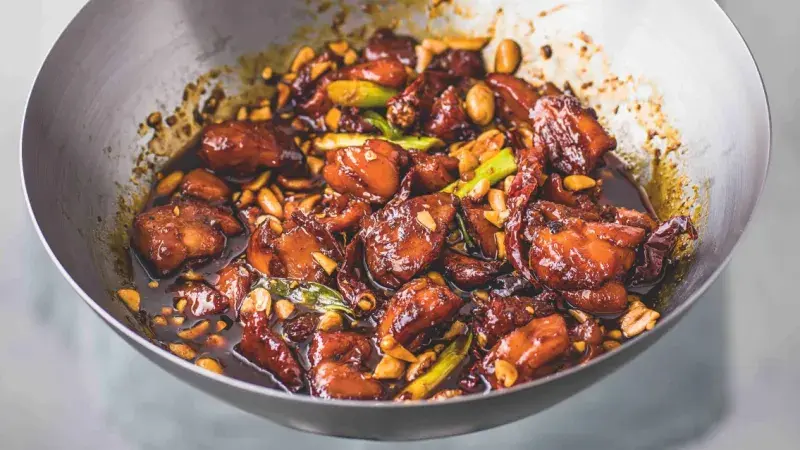 Hotovo kuřecí kung pao s arašidy v pánev.