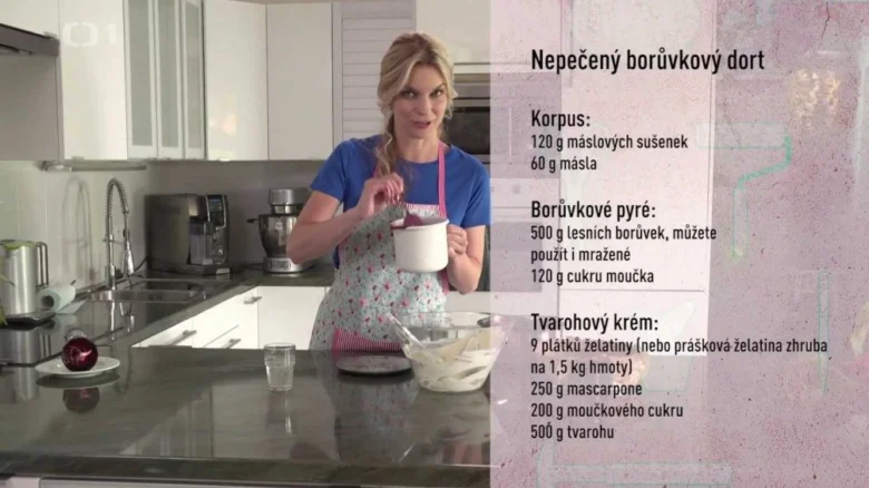 Žena připravuje nepečený borůvkový dort s mascarpone v kuchyni.