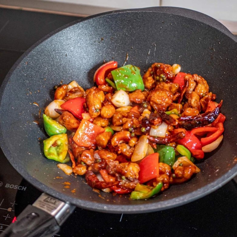Kuře po sečuánsku s paprikou a chilli v pánvi.