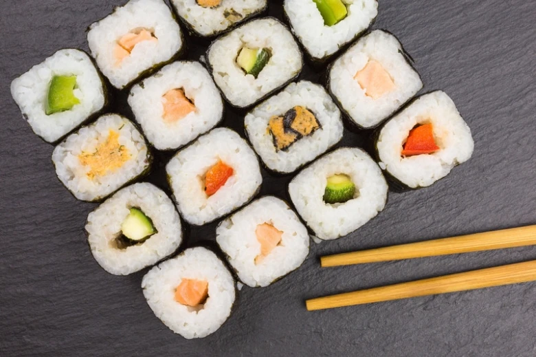 Různé druhy rolí sushimakia na tmavém podkladu.