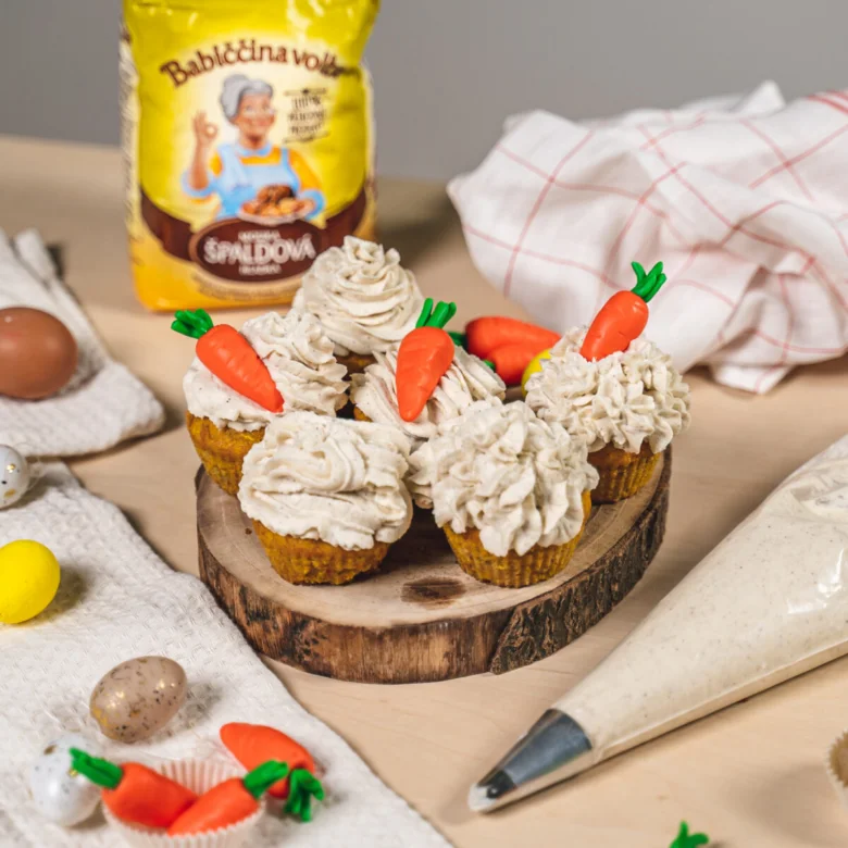 Mrkvové cupcakes s mrazením mrkve na dřevěném podstavci.