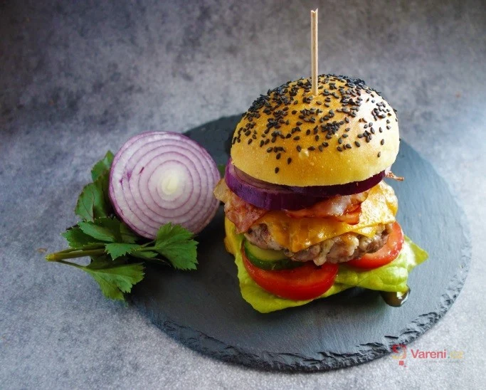 Domácí hovězí hamburger s cibulí na kamenném talíři