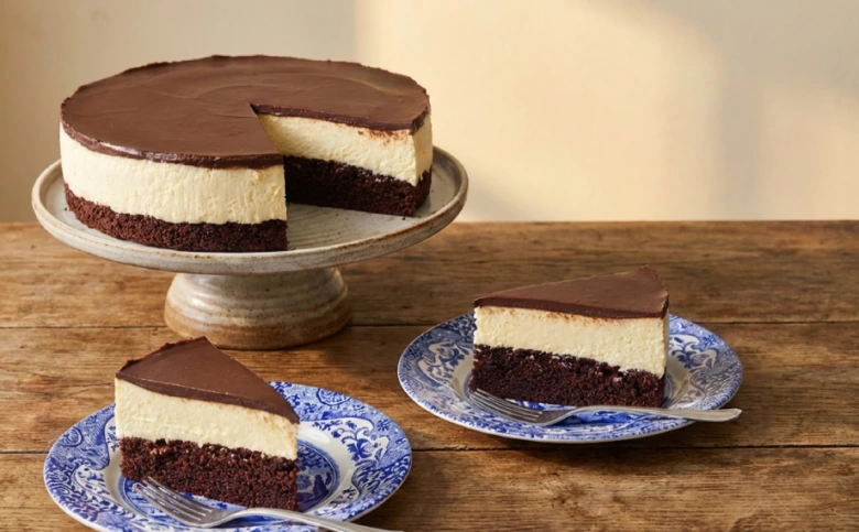 Čokoládový cheesecake s vrstvami na dřevěném stole.