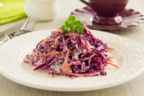 Red cabbage salad with carrots and parsley garnish