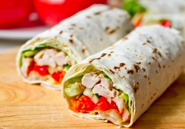 Domácí tortilla s kuřecím masem a čerstvou zeleninou.