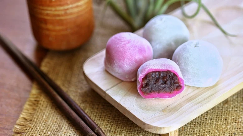 Japonské moči koláčky s fazolovým náplní na dřevěném talíři.