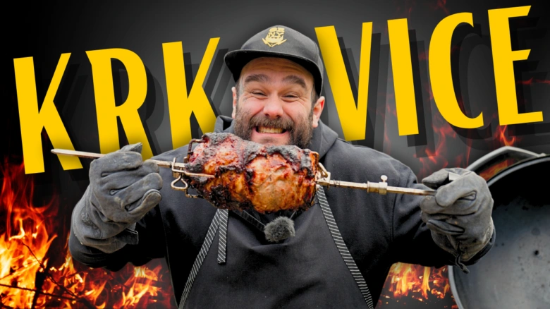 Muž drží na grilu pečenou vepřovou krkovici.