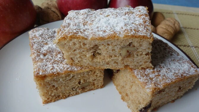 Apple cake slices with walnuts and powdered sugar