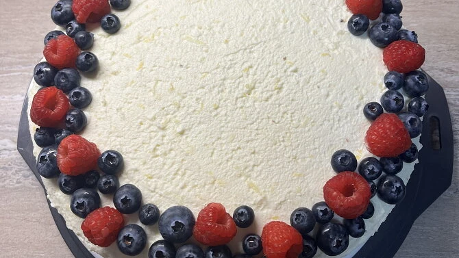 Borůvkový dort s mascarpone ozdobený malinami a borůvkami.