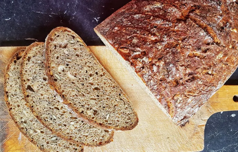 Kousek celozrnného chleba s viditelnou strukturovanou kůrou.
