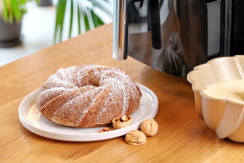 Bábovka s vlašskými ořechy na talíři před horkovzdušnou fritézou.