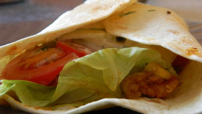 Domácí tortilla s kuřecím masem a čerstvou zeleninou.
