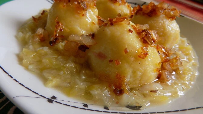 Plněné bramborové knedlíky s kysaným zelím a smaženou cibulkou.