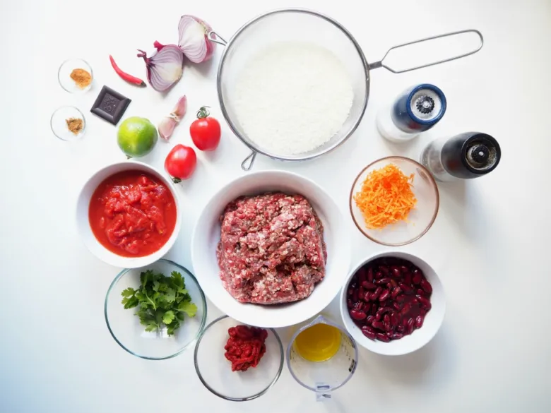 Suroviny na chilli con carne s mletým masem: masa, rajčata, fazole, koření.