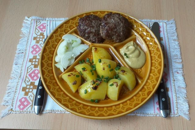 Biftečky z mletého masa s bramborami na talíři
