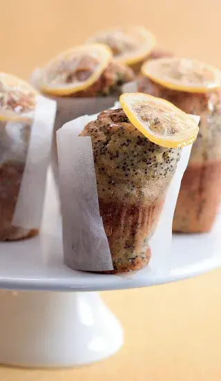 Citronové muffiny s hroznovým semenem na bílém podstavci.