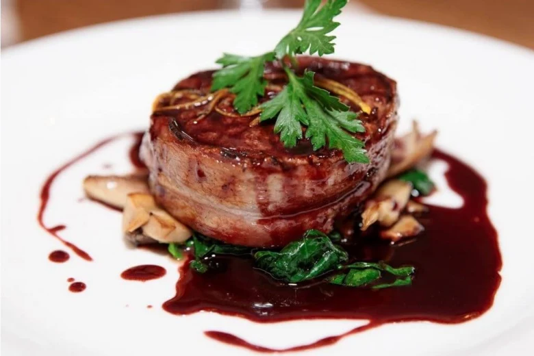 Steak s omáčkou z červeného vína na zelenině.