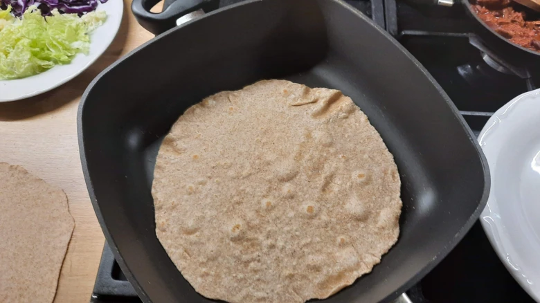 Celozrnná tortilla se peče na pánvi pro domácí recept.