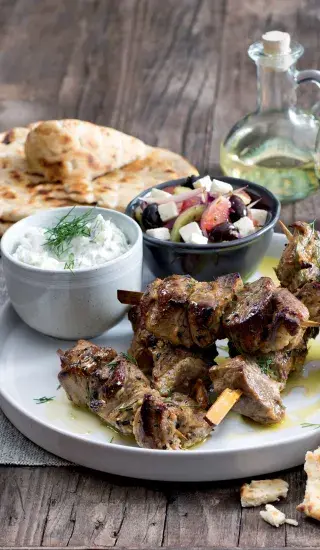 Tzatziki s grilovaným masem na tradičním řeckém talíři.