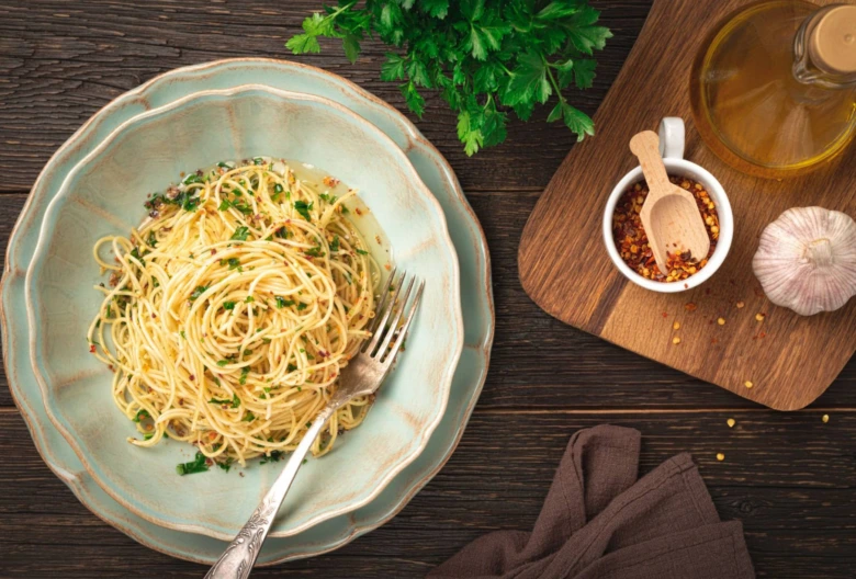 Spaghetti s česnekem, olejem a bylinkami v modré misce.