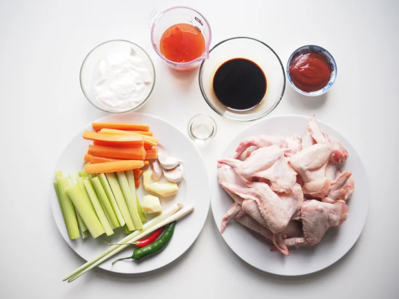 Surová kuřecí křídla s zeleninou a omátkami pro recept.