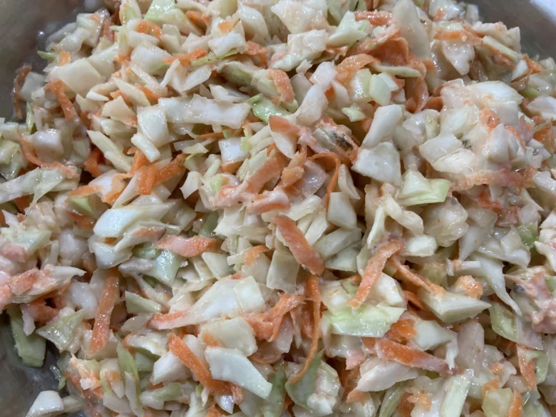 Připravený coleslaw salát z nakrájené kapusty a mrkve.