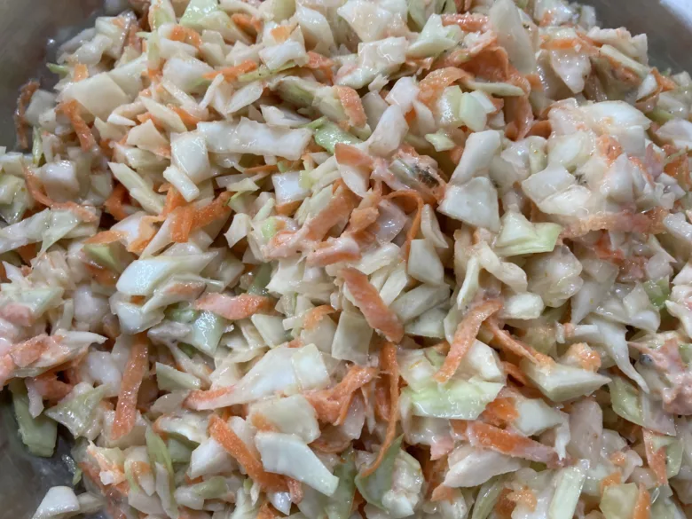 Připravený cole slaw s nakrájeným zelím a mrkví v míse.