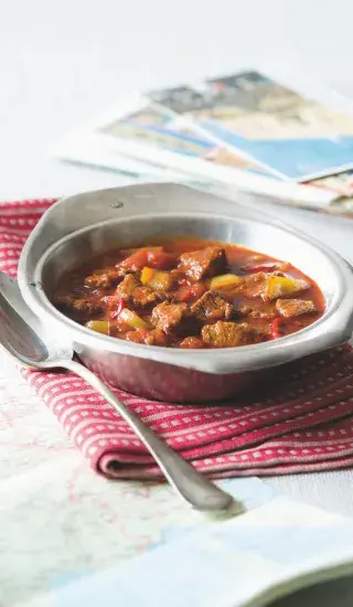 Miska s maďarským vepřovým perkelt na červené ubrousku.