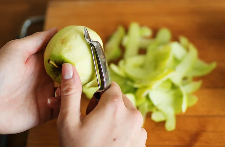 Peeling apple with peeler