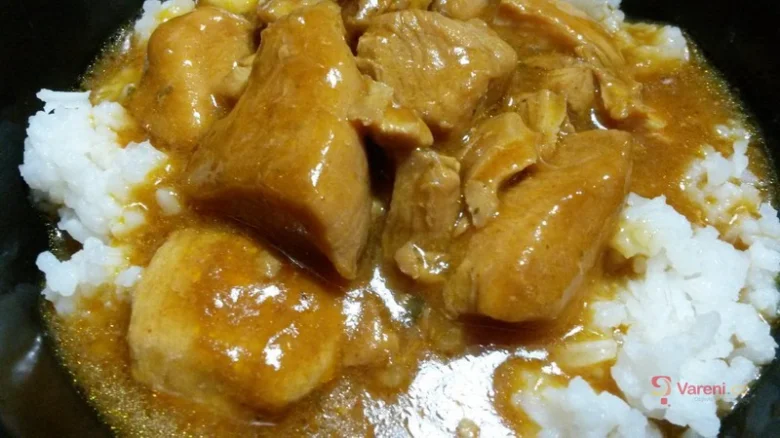 Hot curry s kuřecím masem podávaný na bílém rýži.