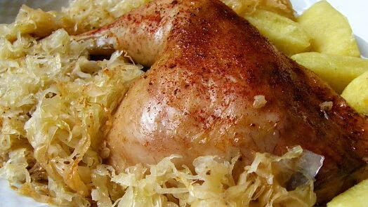 Pečené kuře podávané se zelím na kyselo a bramborami.