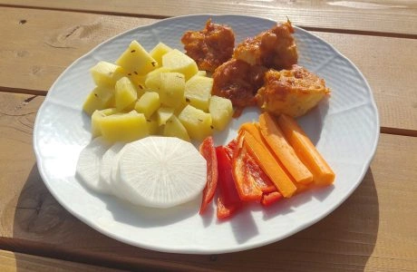 Bílá talíř s vařenými bramborami a zeleninou bez masa.