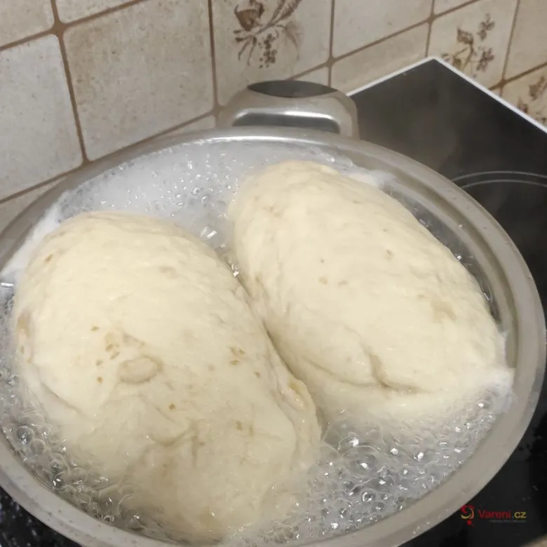 Dva kusy kynutého těsta se vaří v hrnci na plotně.