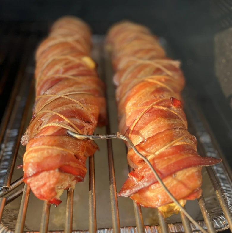 Dva kusy masa obalené v briošce na grilu připravené k pečení.