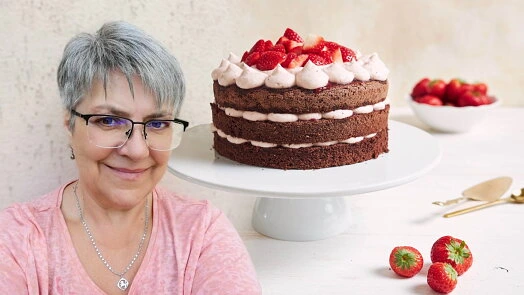 Woman with chocolate layer cake and strawberries