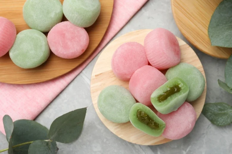 Japonské mochi koláčky v růžové a zelené barvě s výplní.