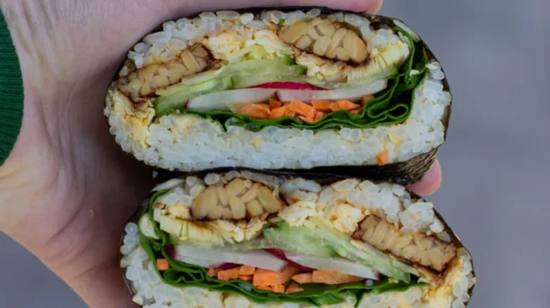 Křížový řez sushi rolí s grilovaným seitanem a zeleninou.