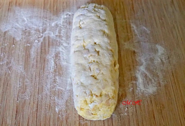 Kus těsta z mouky na dřevěném prknu před vařením knedlíků.