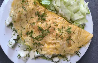 Připravená bílková omeleta s bylinkami na talíři.