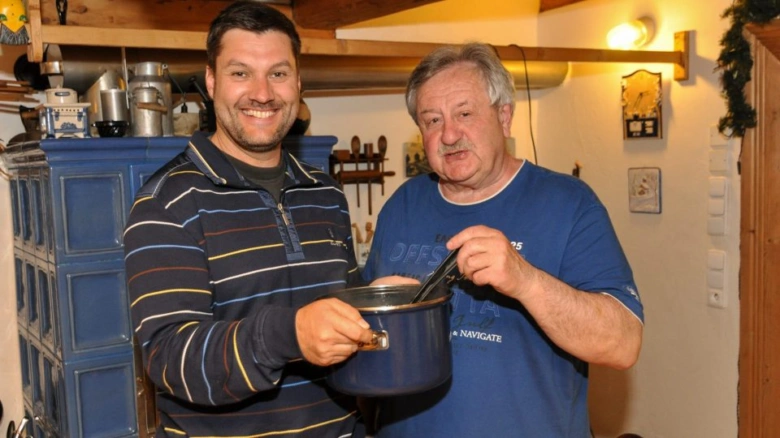 Dva muži připravují polévku v kuchyni.