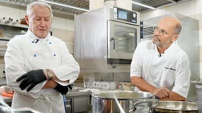 Dva šéfkuchaři v kuchyni při přípravě guláše.