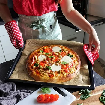 Domácí pizza s rajčaty a bazalkou na plechu po upečení.