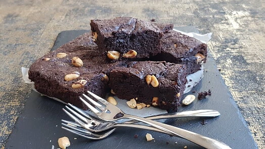 Čokoládové brownies s ořechy na kamenném podkladu.