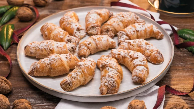 Zlatohnědé lívance s vlašskými ořechy posypané cukrem.
